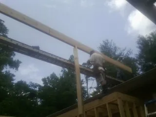 Carpenter setting a ridge beam over a new addition frame — Ice Dam Removal by Roofing Brothers in Glen Dale